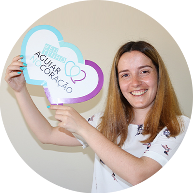 Senhora sorridente de cabelo castanho claro a segurar um coração